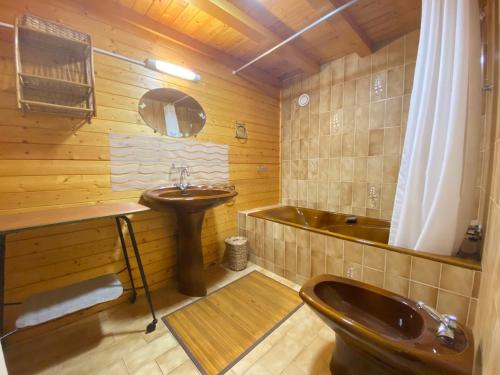 y baño de madera con lavabo y bañera. en Maison 4 pers à 200m de la plage et du surf - WiFi, jardin et parking - FR-1-231-170, en Bretignolles-sur-Mer