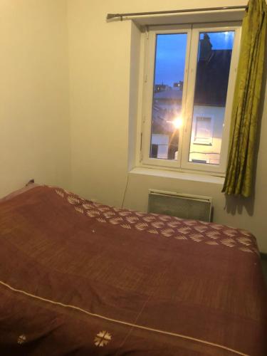 un lit dans une chambre avec une fenêtre dans l'établissement Petit appartement centre ville Granville, à Granville