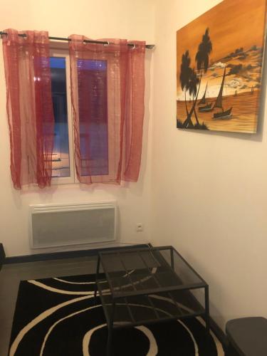 - un salon avec une table en verre et une fenêtre dans l'établissement Petit appartement centre ville Granville, à Granville