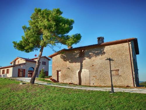 an old brick building with a tree next to it at Hidden Hamlet Stay with Pool in SantʼAngelo in Vado