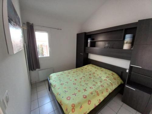 - une petite chambre avec un lit et une couverture jaune dans l'établissement Maison à 150m de la Plage avec Piscine, Jardin et WIFI – Bretignolles-sur-Mer - FR-1-231-251, à Bretignolles-sur-Mer