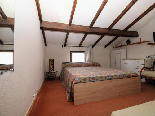 1 dormitorio con 1 cama en una habitación con techos de madera en Appartement Saint-Cyprien, 2 pièces, 4 personnes - FR-1-309-353, en Saint-Cyprien