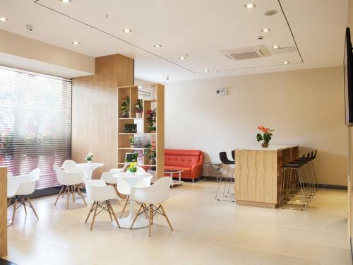 a waiting room with white chairs and a red couch at 7Days Premium Guilin central plaza in Guilin