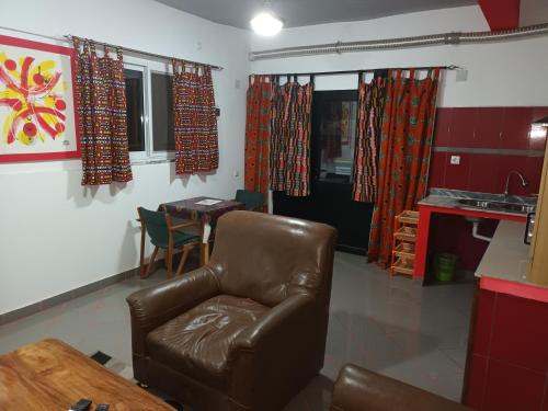 sala de estar con silla de cuero y mesa en HOTEL BADINCA Alojamento Low Cost in Bissau avenida FRANCISCO MENDES en Bissau