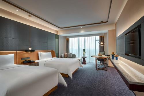 上海市にあるPrimus Hotel Shanghai Hongqiaoのベッド2台、薄型テレビが備わるホテルルームです。