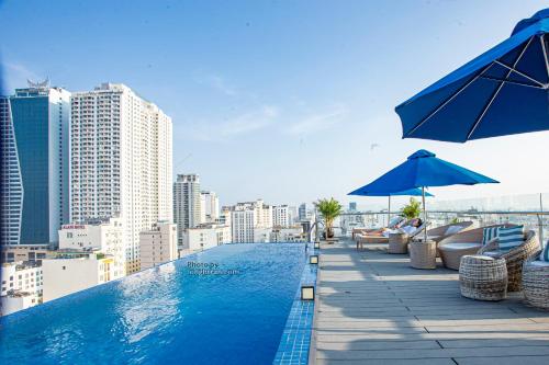 a swimming pool with chairs and umbrellas on a building at Grand Ocean Luxury Boutique - Infinity Rooftop Pool in Da Nang