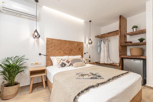 a bedroom with a large bed and a plant at Galazia Boutique Apartments in Naxos Chora