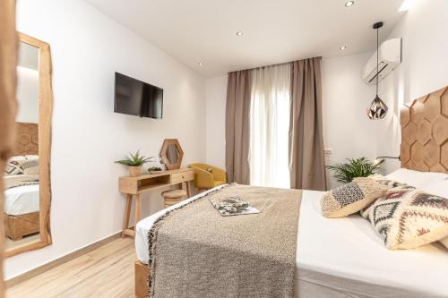 a hotel room with a bed and a television at Galazia Boutique Apartments in Naxos Chora