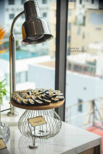a plate of donuts on a stand with a light at Grand Ocean Luxury Boutique - Infinity Rooftop Pool in Da Nang