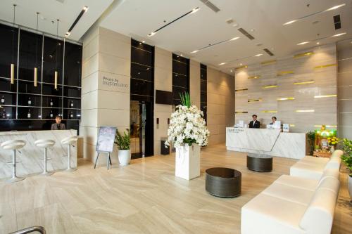 a lobby with white chairs and a reception desk at Grand Ocean Luxury Boutique - Infinity Rooftop Pool in Da Nang
