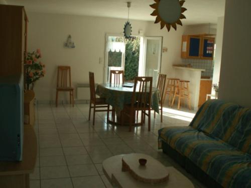 un salon avec un canapé, une table et des chaises dans l'établissement Villa Calme avec Jardin, Proche Plage et Commerces, Animaux Acceptés sur Demande - FR-1-476-118, à La Faute-sur-Mer