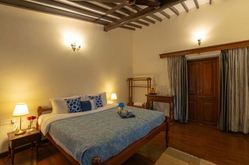 a bedroom with a large bed with blue pillows at StayVista at La Tranquillità with Pvt Pool in Saligao