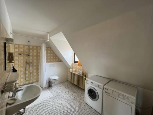 uma casa de banho com um lavatório e uma máquina de lavar roupa em Ferienwohnung Torster #9 em Hameln