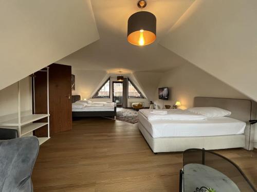 um quarto no sótão com 2 camas e uma escada em Ferienwohnung Torster #9 em Hameln