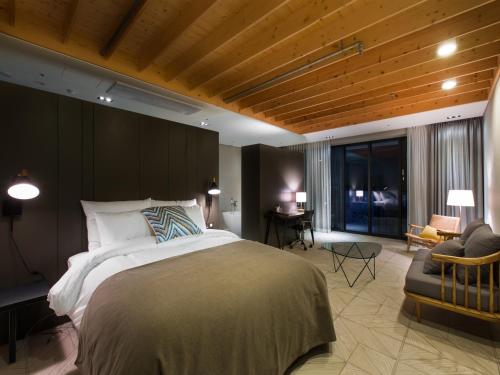 ソウルにあるSR ホテル ソウルのベッドルーム(大型ベッド1台付)、リビングルームが備わります。