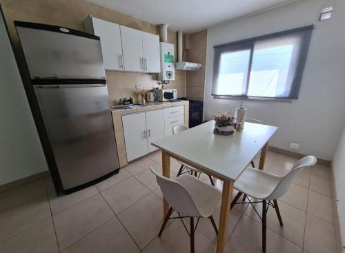 薩爾塔的住宿－Departamentos salta，厨房配有桌椅和冰箱。