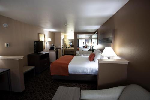 a hotel room with a bed and a television at Hawthorn Suites by Wyndham Napa Valley in Napa