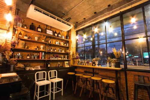 a bar with stools in a room with a window at Khaolak Tony Lodge in Khao Lak