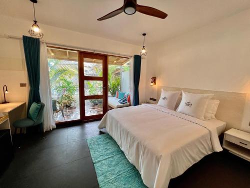a bedroom with a bed with a ceiling fan at Seaside Dhigurah in Dhigurah