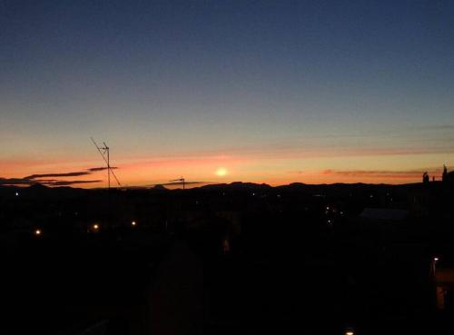 a sunset over a city with the sun in the sky at Studio terrasse 27m2 RESERVATION SUR RBNB in Perpignan