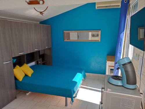 a blue room with a bed and a desk at Studio terrasse 27m2 RESERVATION SUR RBNB in Perpignan