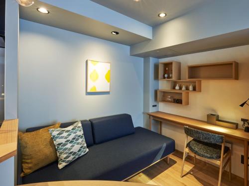 a living room with a blue couch and a counter at COCOSHUKU AKASAKA Premium in Tokyo