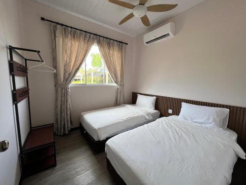 a hotel room with two beds and a window at TANJUNG GROVE VILLAS 