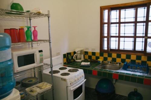 a kitchen with a stove and a microwave at Casa Jaguar in Copan Ruinas