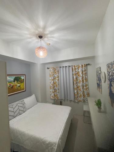 1 dormitorio con cama blanca y sofá en SEA Residences in Pasay near Mall of Asia 2BR and 1BR en Manila