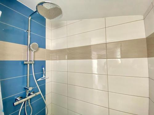 La salle de bains est pourvue d'une douche et de carrelage bleu et blanc. dans l'établissement Maisonnette rénovée proche plage des Dunes, patio et confort moderne - FR-1-231-282, à Bretignolles-sur-Mer