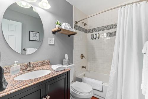 a bathroom with a sink and a toilet and a mirror at MODERN LIVING! CAMELBACK EAST-BILTMORE HOME in Phoenix