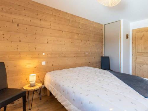 a bedroom with a bed and a wooden wall at Appartement Valmorel, 3 pièces, 6 personnes - FR-1-291-890 in Valmorel