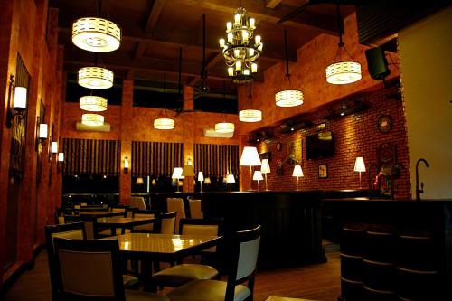 a dining room with tables and chairs and chandeliers at Central Park Tower Resort in Angeles