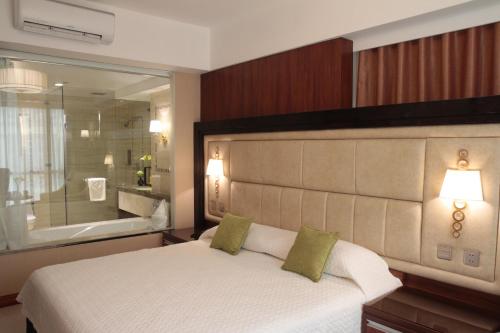 a bedroom with a large bed and a large bathroom at Central Park Tower Resort in Angeles