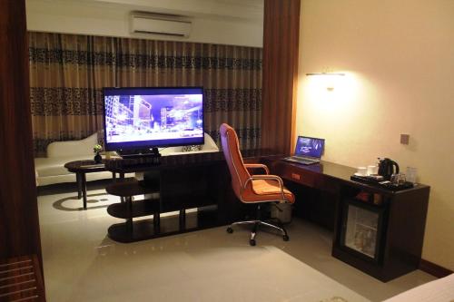 a room with a desk with a monitor and a chair at Central Park Tower Resort in Angeles