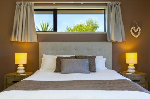 sypialnia z dużym łóżkiem i oknem w obiekcie Ocean View Beachfront Apartment w mieście Blenheim
