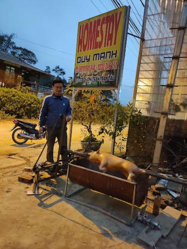a man standing next to a pig in a trough at Homestay duy mạnh gần suối nước khoáng nóng trạm tấu in Cham Ta Lao