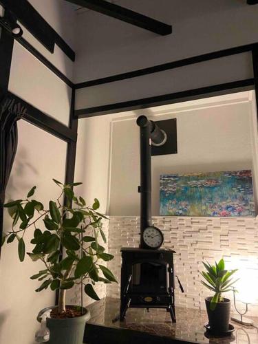 a fireplace in a living room with two potted plants at リベラ小波月古民家再生 海岸横プライベートビーチ並み in Iwada