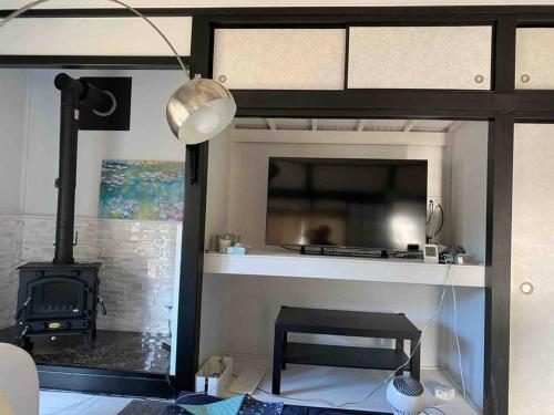 a living room with a fireplace and a stove at リベラ小波月古民家再生 海岸横プライベートビーチ並み in Iwada