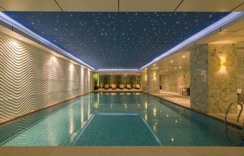 - une piscine avec un plafond étoilé dans un bâtiment dans l'établissement Avic Hotel Beijing, à Pékin