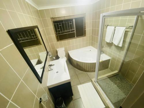 a bathroom with a sink and a toilet and a shower at Private 3-bed Unit in Johannesburg with Power Backup in Roodepoort