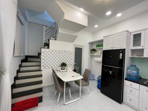 a kitchen and dining room with a table and a staircase at Vika Homestay in Ho Chi Minh City