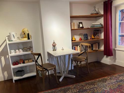 Habitación con mesa, sillas y estante para libros. en Le Cazalet, en Saint-Sever
