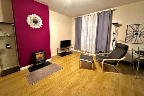 sala de estar con chimenea y pared púrpura en Two Bedroom Entire Flat in Darlington with Free Parking, WiFi and lots more, en Darlington