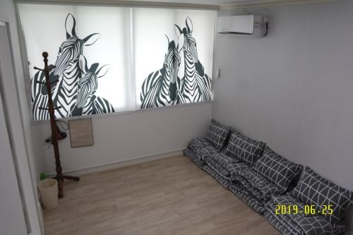 una sala de estar con 3 cebras pintadas en la pared en Joa Guesthouse en Gwangju