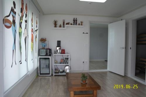 een woonkamer met witte muren en een houten tafel bij Joa Guesthouse in Gwangju