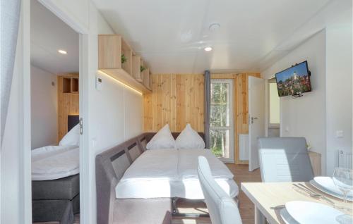 Habitación pequeña con cama y mesa de comedor. en Tiny Haus 34 Am Brombachsee en Pleinfeld