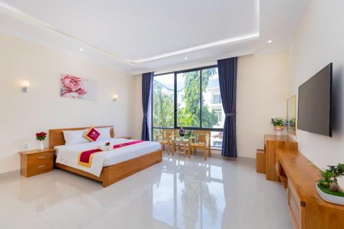 Schlafzimmer mit einem Kingsize-Bett und einem TV in der Unterkunft Luxury Chilinh - Large Swimming Pool - 200M To The Sea in Vũng Tàu