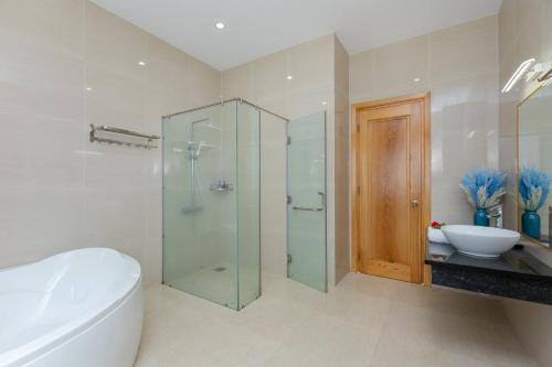 ein Badezimmer mit Glasdusche und Waschbecken in der Unterkunft Luxury Chilinh - Large Swimming Pool - 200M To The Sea in Vũng Tàu