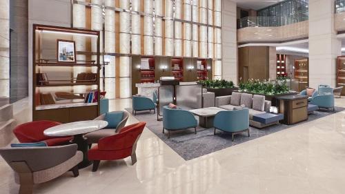 a lobby with colorful chairs and tables in a building at Swissôtel Shenyang in Shenyang